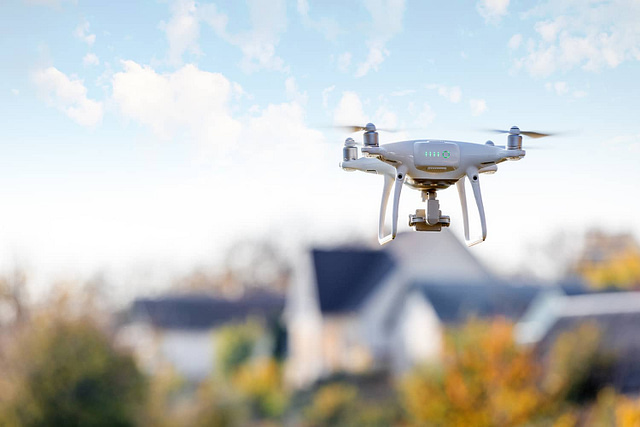 drone taking picture of roof for roof measurement software vs hand measuring